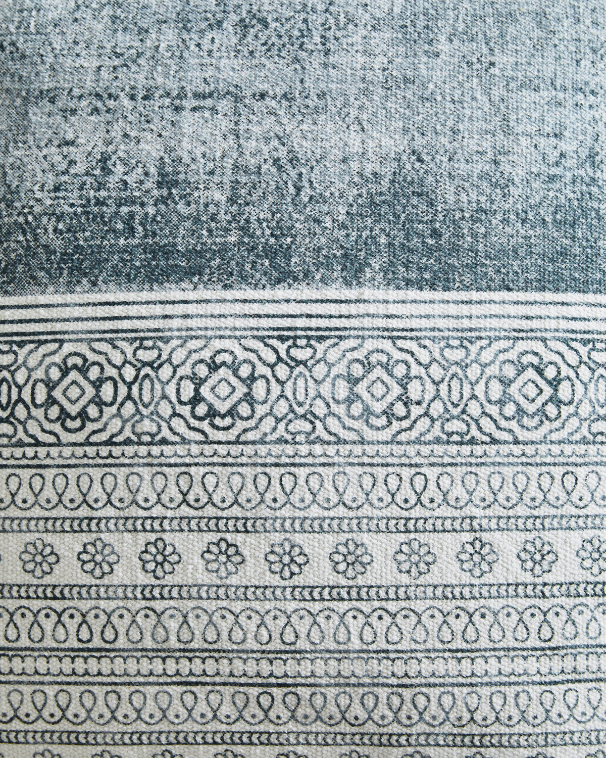 Close-up of blue woven pillow fabric with stitched horizontal pattern band