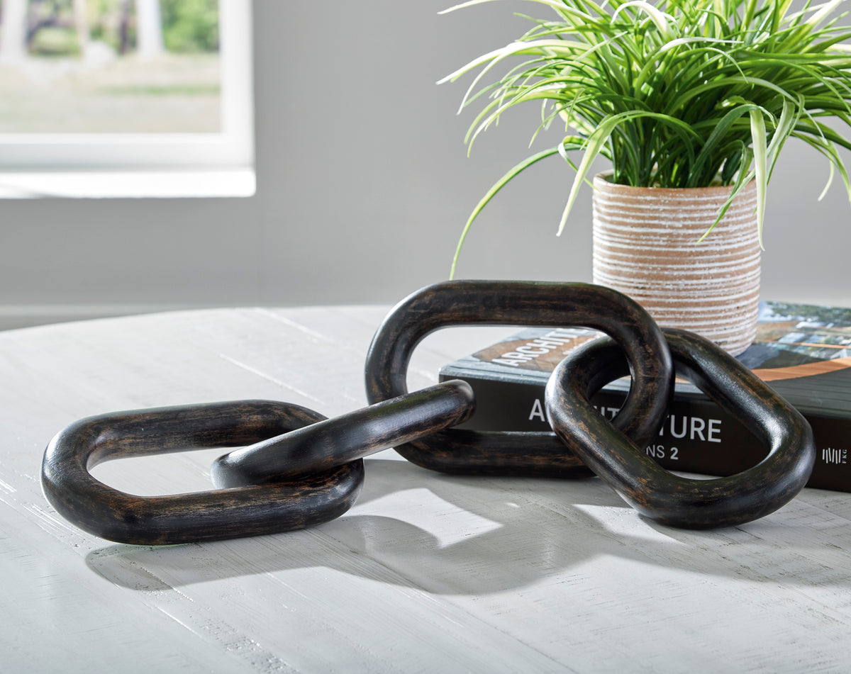 Metal sculpture with dark oval chain links, coiled and interlocked