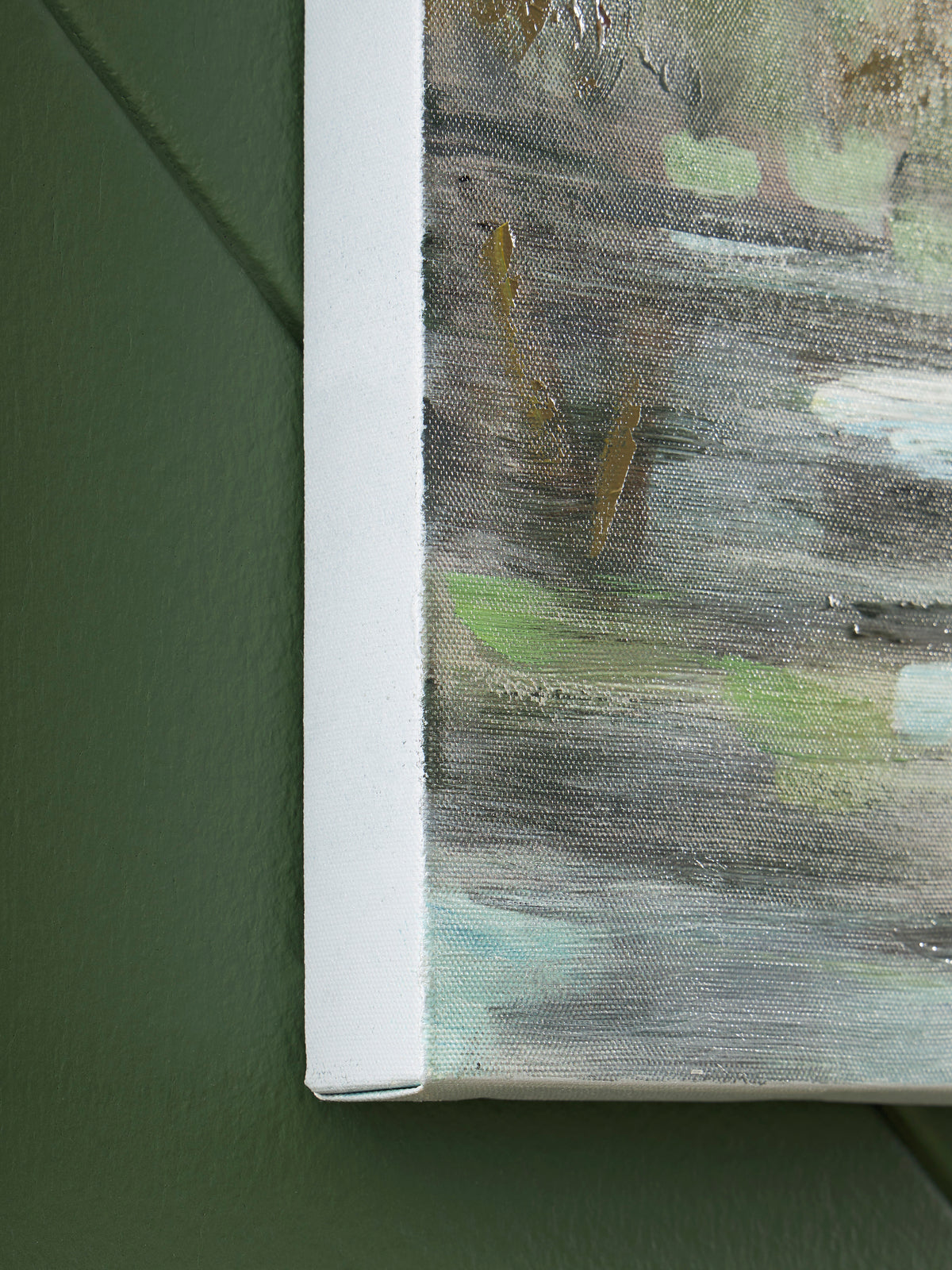 Close-up of textured wall art edge in white frame with green paint