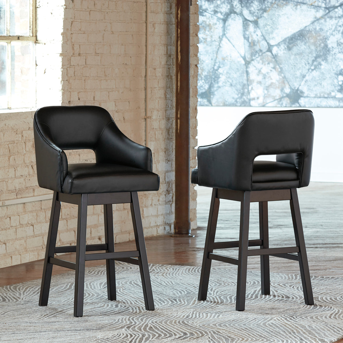 Set of 2 black bar height bar stools with padded arms, back, and footrest legs