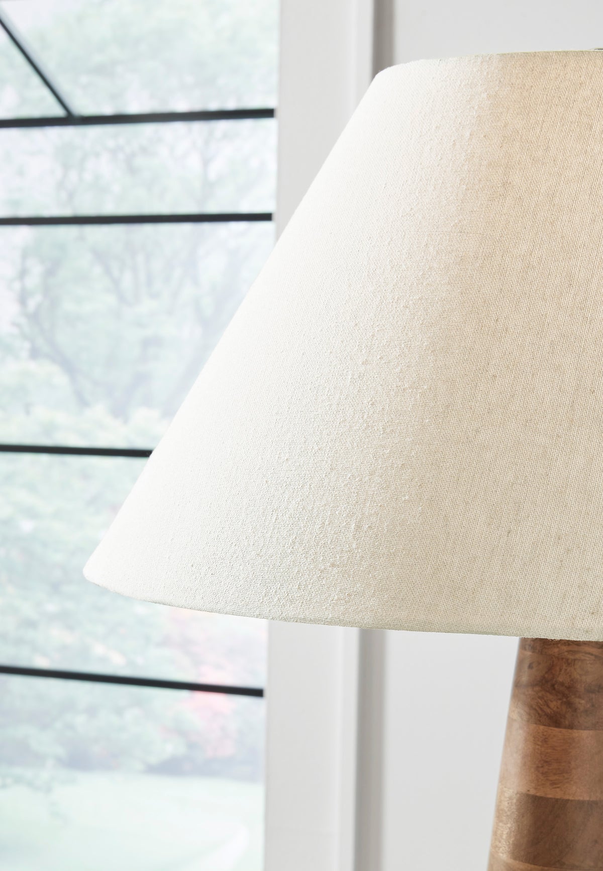 Wood floor lamp with beige fabric drum shade and carved wood column stem