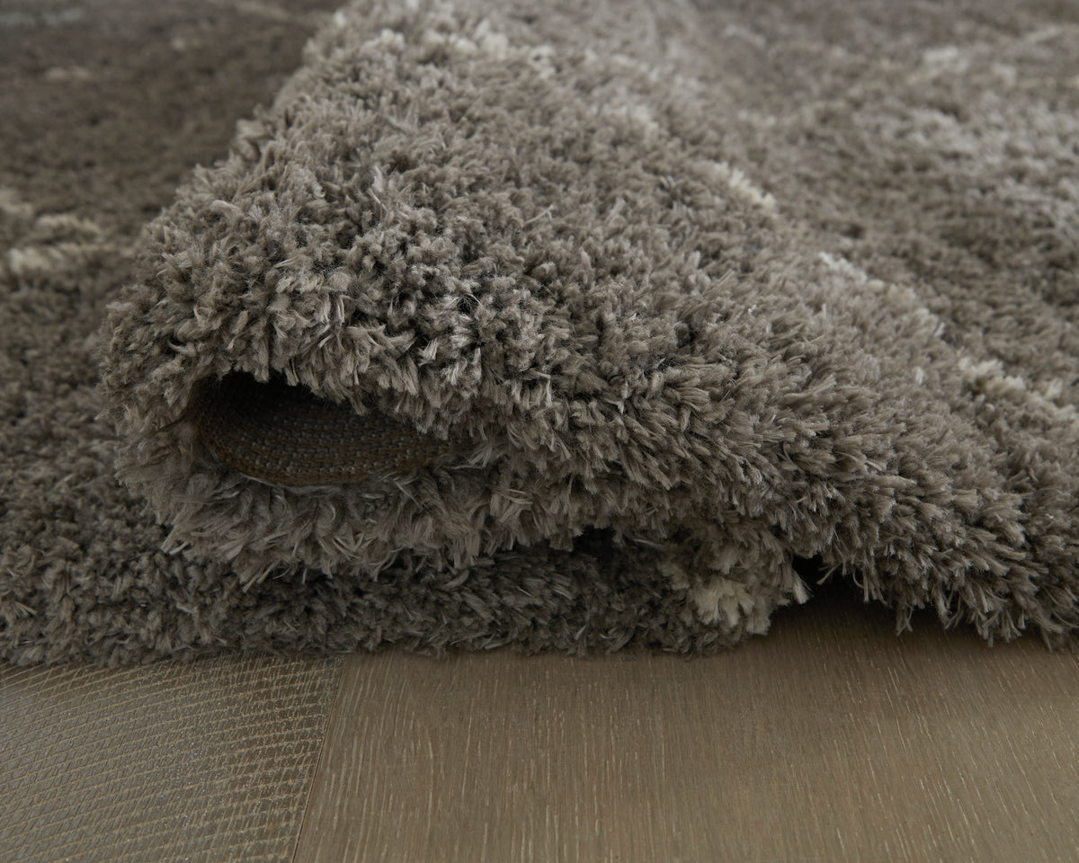 Gray shag rug with plush long pile and visible overlocked edge