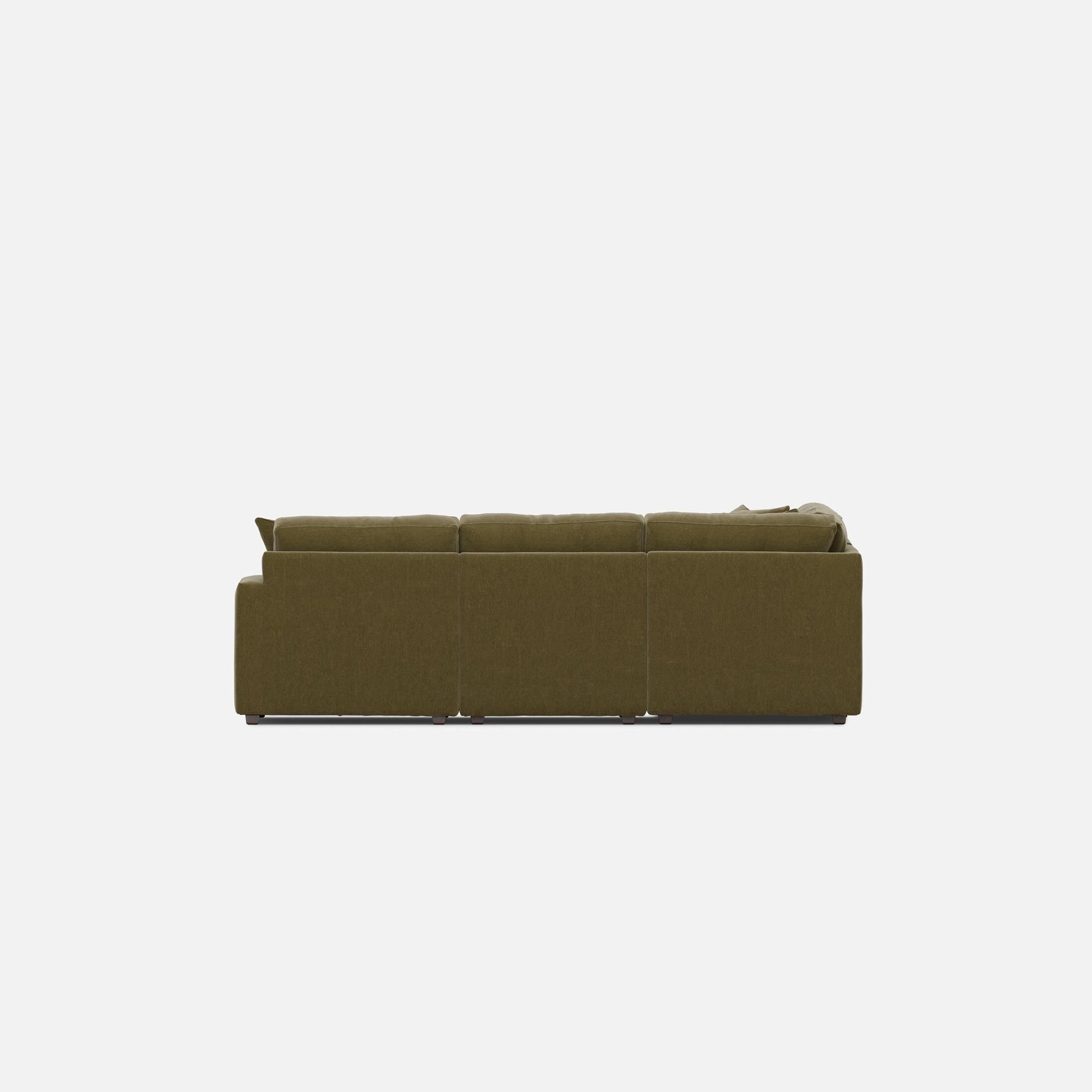 Olive green sectional sofa from the side with wide armrests and tufted cushion backs