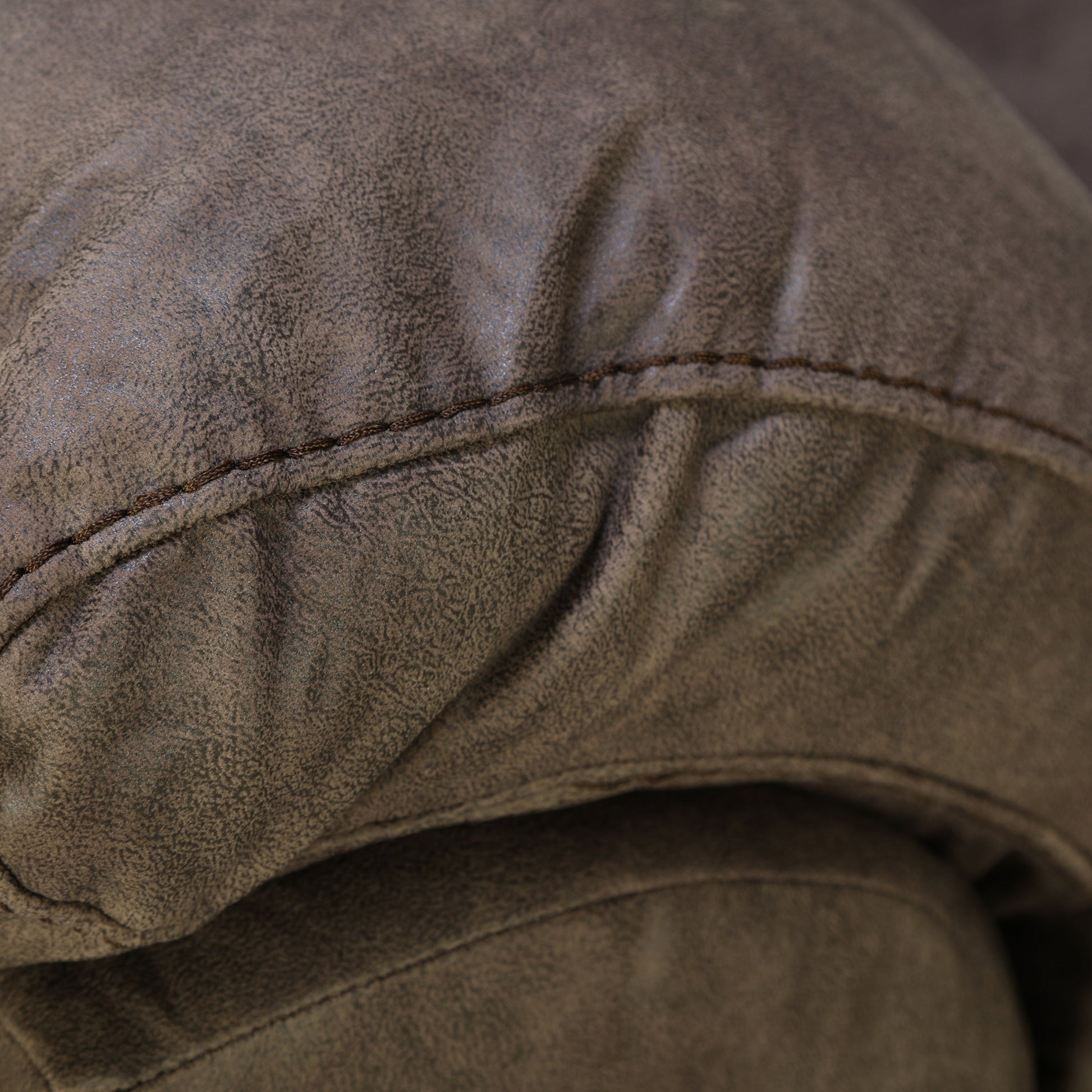 Wall-hugging power recliner cushion close-up with dark brown faux leather texture