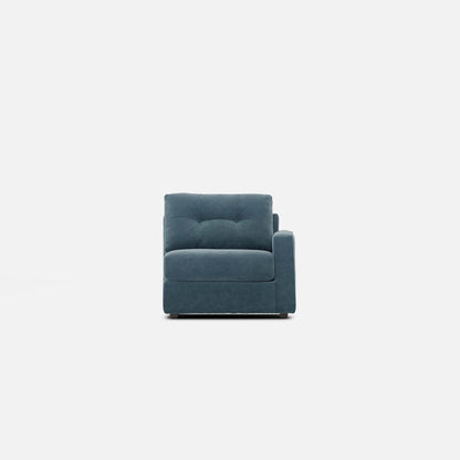 Modular chair in teal fabric with padded arms, seat cushion, and tufted back.