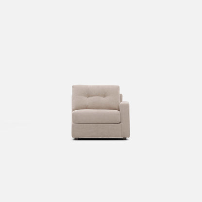 Light beige modular chair with armrest, tufted back, and cushioned seat