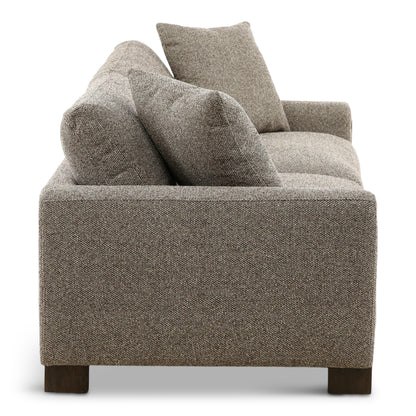 Gray fabric sofa backrest with three tall throw pillows and textured upholstery.