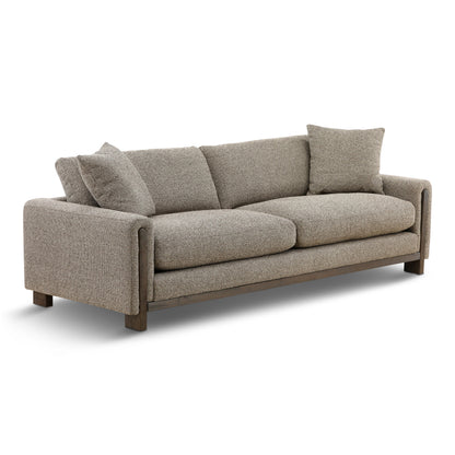 Gray fabric sofa with wide arms and three back pillows, angled side view.