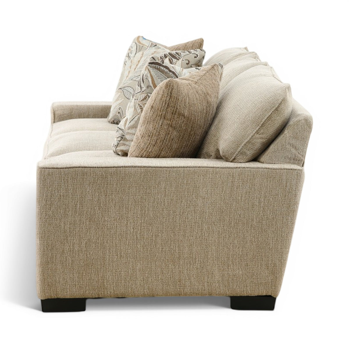 Beige fabric sofa with multiple neutral and patterned pillows on the backrest, black feet