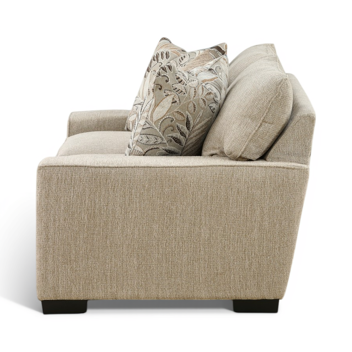 Light beige loveseat corner view with two leaf-pattern pillows and curved rolled arms