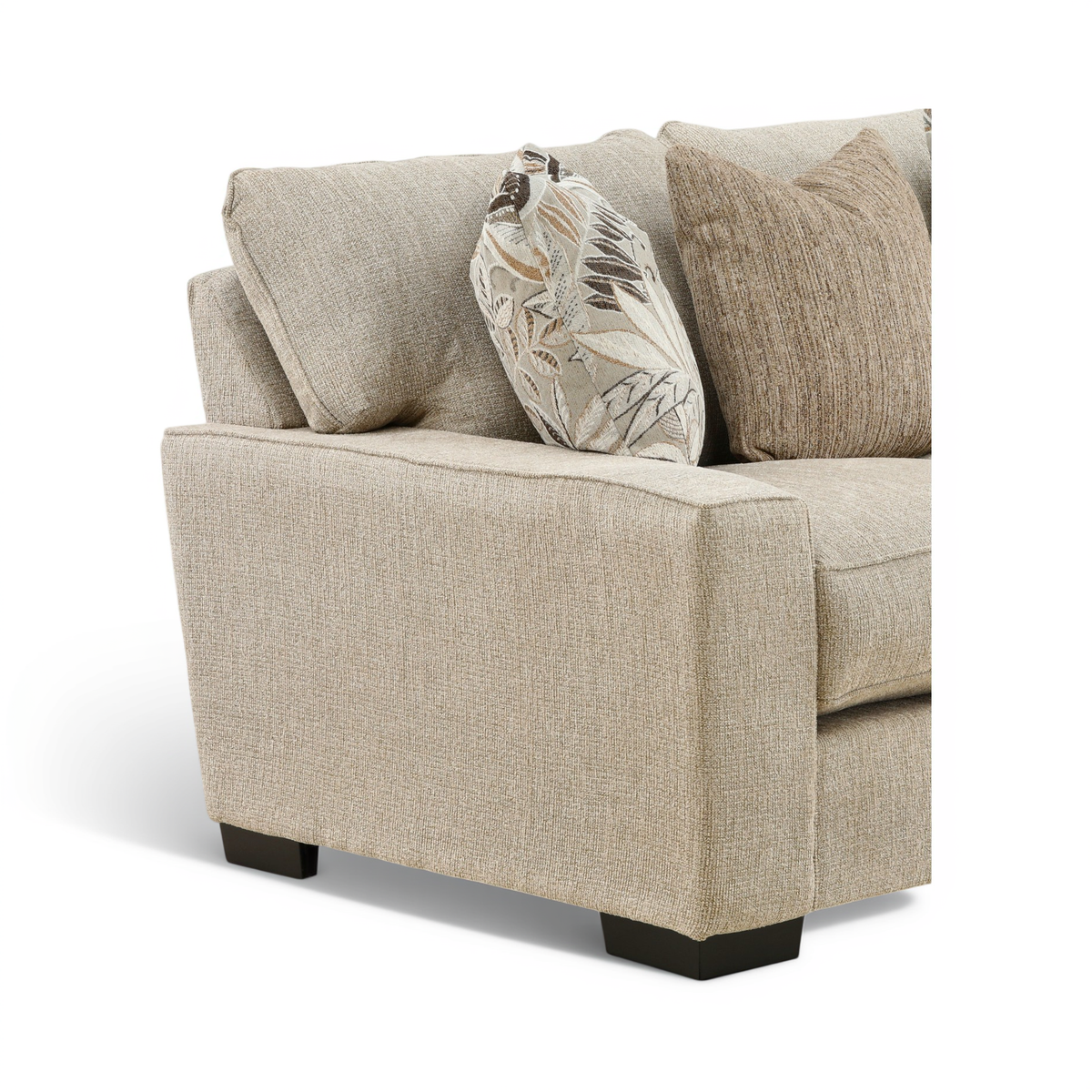 Light beige loveseat arm and seat detail with leaf-print and solid accent pillows