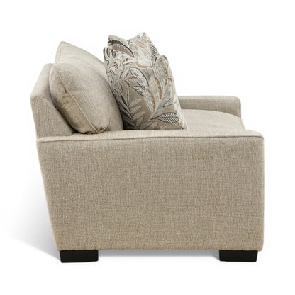 Beige upholstered chair with two throw pillows and dark legs