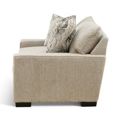 Beige fabric chair with patterned pillow accents and square arms