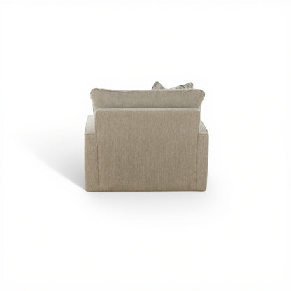 Beige upholstered swivel chair back view with two cushions and leaf-pattern pillow