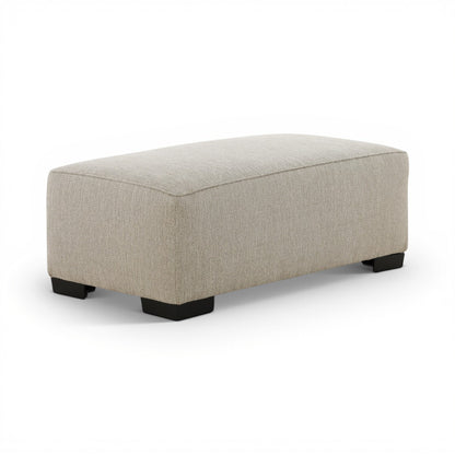 Upholstered ottoman, light beige cushion top and black legs, side view