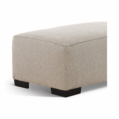 Light beige upholstered ottoman with rounded corner edges and black legs