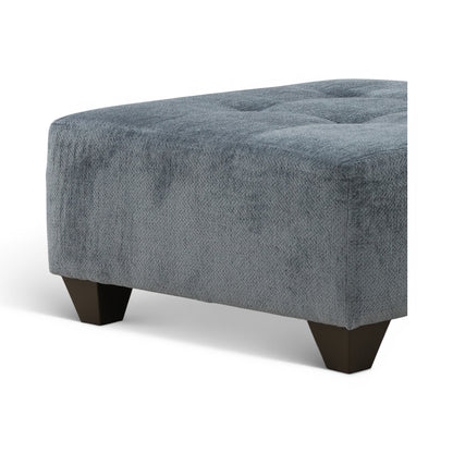 Low-profile upholstered ottoman with tufted top and dark wooden legs