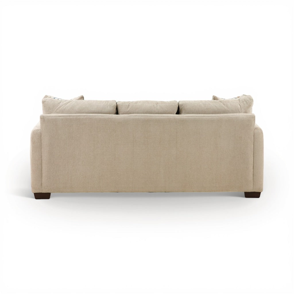 Parchment sofa chaise with tufted back cushions and rounded arms; dark feet visible.
