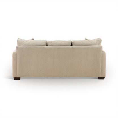 Parchment sofa chaise with tufted back cushions and rounded arms; dark feet visible.