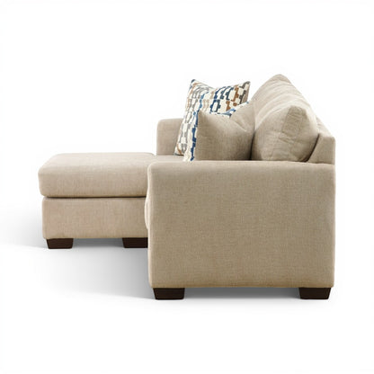 Parchment chaise sofa with tufted back cushions and decorative geometric pillows