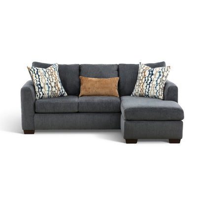 Charcoal sofa chaise with chaise ottoman, two patterned pillows, and a brown accent cushion.