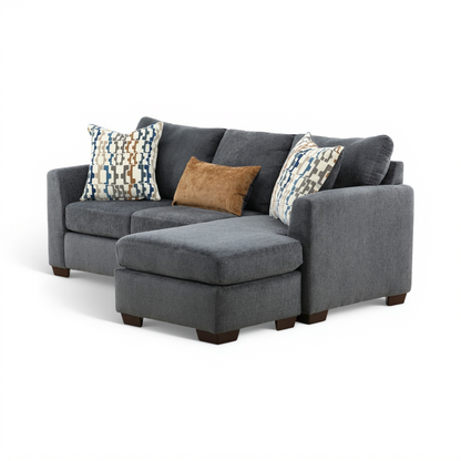 Charcoal sofa chaise with chaise ottoman and two patterned square pillows.