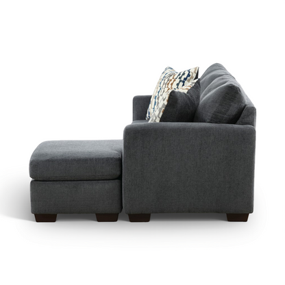 Charcoal sofa chaise with chaise extension, armrest and patterned throw pillow.