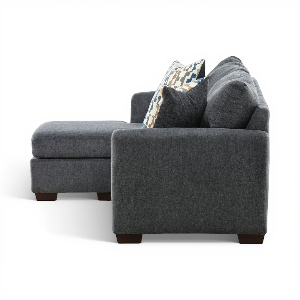 Charcoal sofa chaise side view with large arm cushion and patterned pillows.