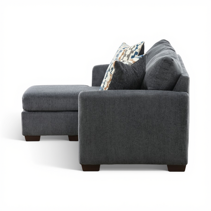 Charcoal sofa chaise side view with large arm cushion and patterned pillows.