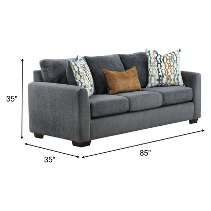 Dark gray sofa with three blue geometric pillows and one tan accent pillow