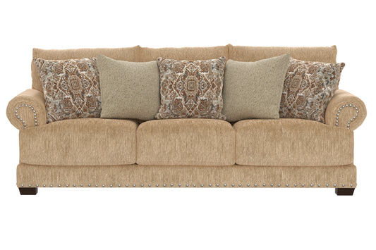Sand upholstered sofa with rounded arms, three seat cushions, studded trim, patterned throw pillows