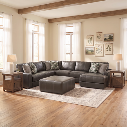 Dark gray sectional sofa with chaise ottoman and patterned cushions.