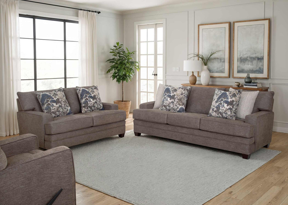 Gray loveseat sofa with two back cushions and blue-gray floral accent pillows