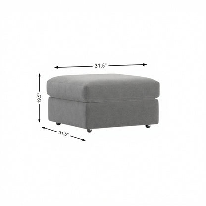 Storage ottoman in light gray fabric, padded top with hinged lid and legs.