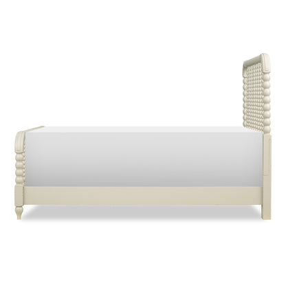 Cream panel bed side view with beadboard headboard and clean paneled footboard.