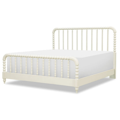 Cream panel bed angled view with arched headboard top and vertical beadboard posts.