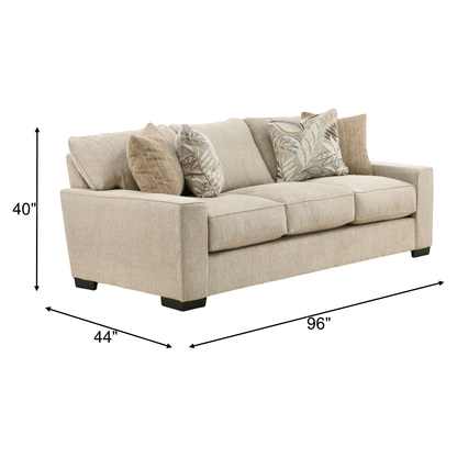Beige fabric sofa with tufted seat, square arms, and three throw pillows; 96 in wide