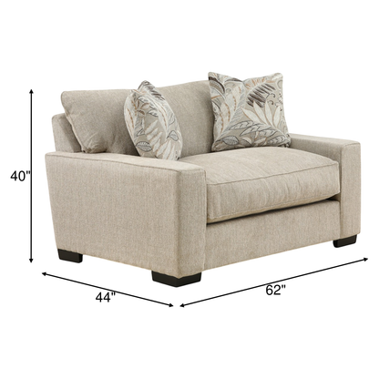 Light beige upholstered chair with square arms and three accent pillows