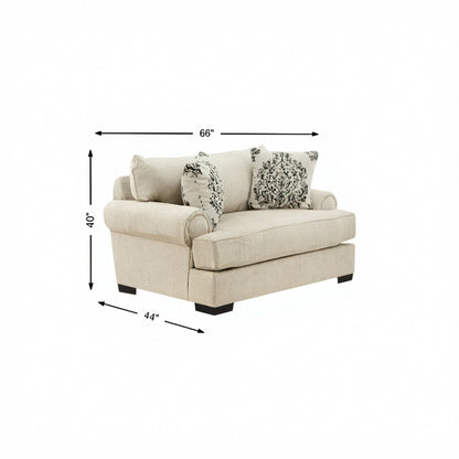Beige upholstered XL armchair with rolled arms and two patterned throw pillows