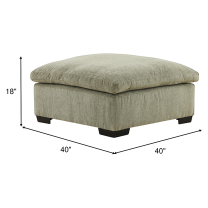 Light green upholstered ottoman with tufted square top and black block legs