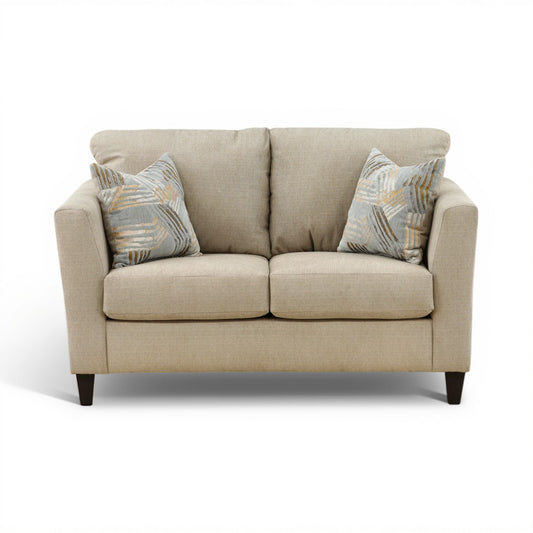Light beige upholstered loveseat with two patterned accent pillows and square arms