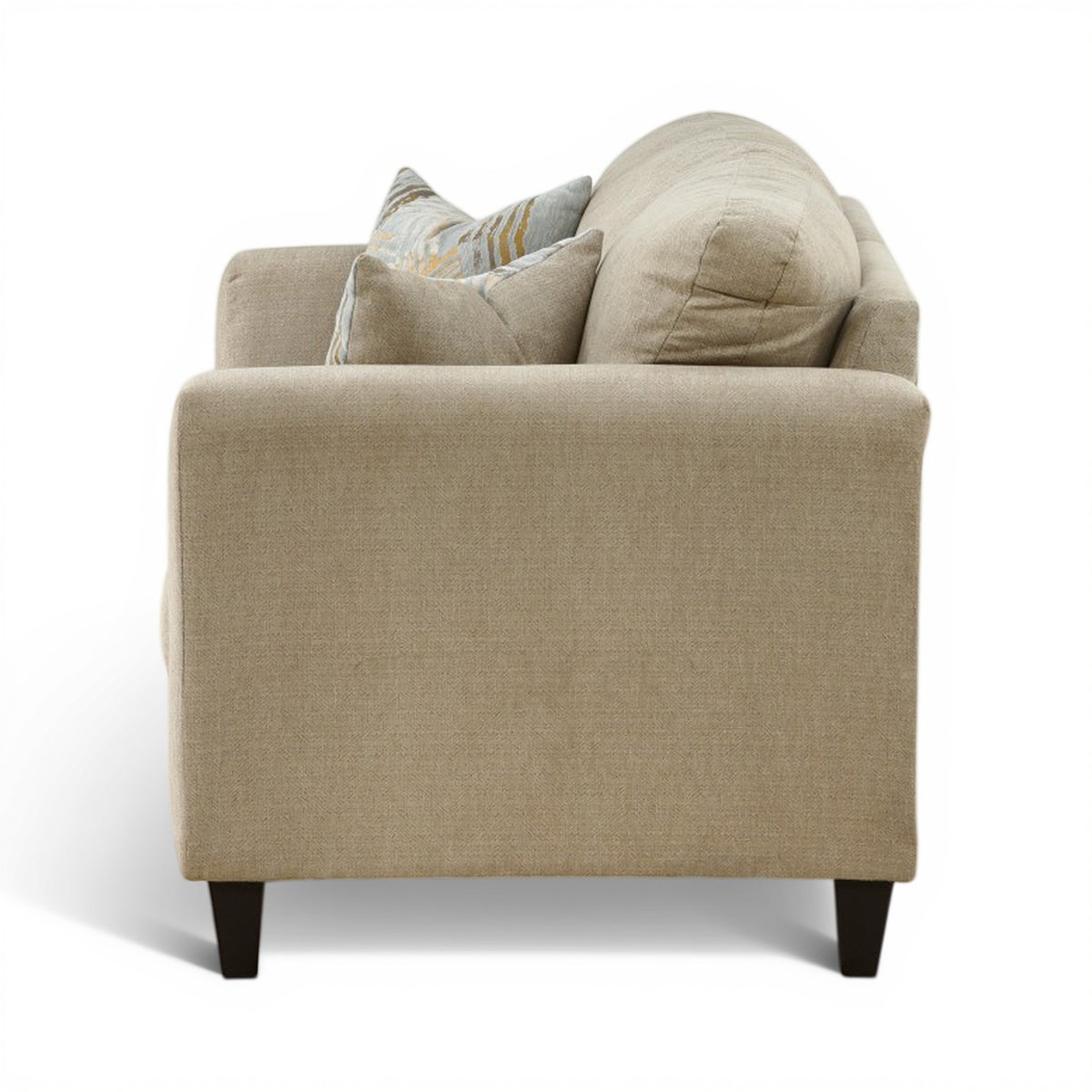 Light beige loveseat with two beige patterned pillows and plush rolled arms