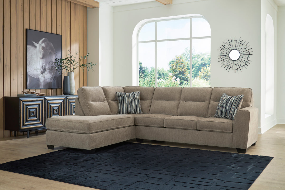 Left-facing mocha sectional with chaise and striped pillows in a living room.