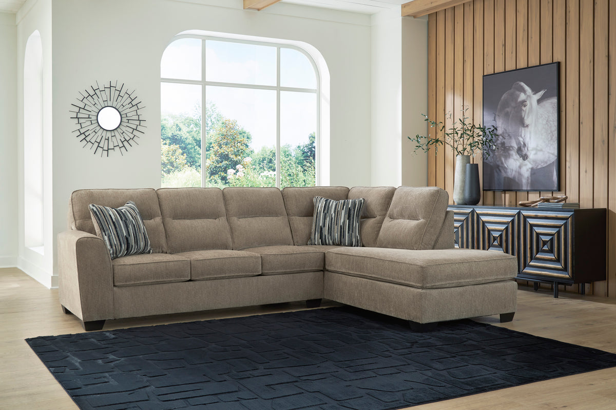Right-facing mocha sectional with chaise and striped pillows in a living room.
