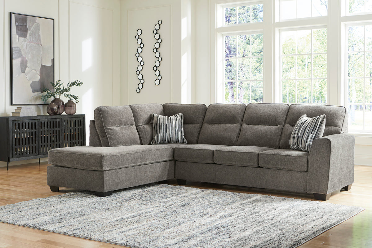 Left-facing graphite sectional with chaise and striped pillows in a living room.