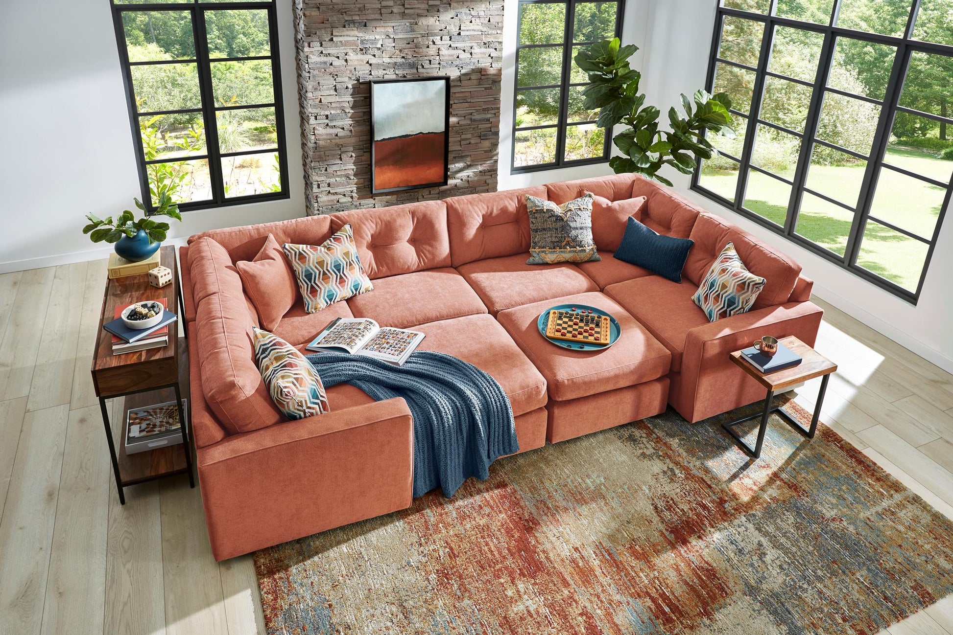 Terracotta modular sectional sofa with decorative pillows and a draped throw blanket