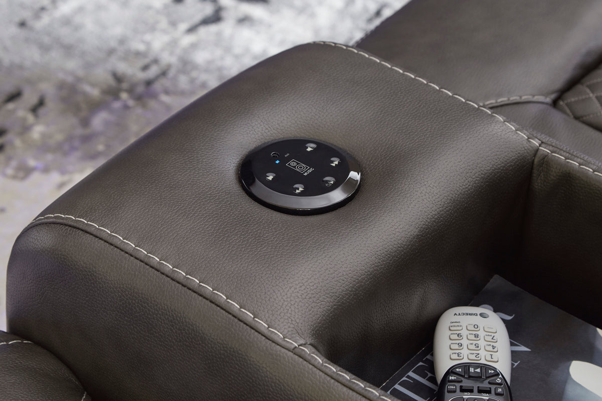 Reclining control button on dark armrest with remote