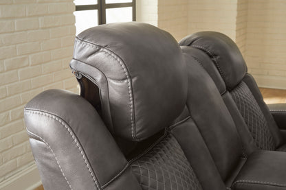 Dark gray recliner with tufted back cushion detail and stitched arm upholstery