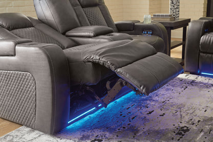 Dual power reclining loveseat with console in dark gray, open footrest and blue LED lights