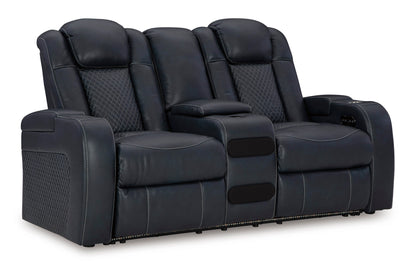 Dark power reclining loveseat with quilted back cushions and armrest controls, angled view